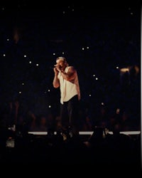 a man singing into a microphone at a concert