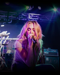 a woman singing into a microphone at a concert