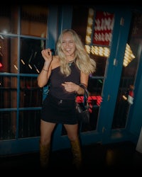 a blonde woman in a black top and black shorts
